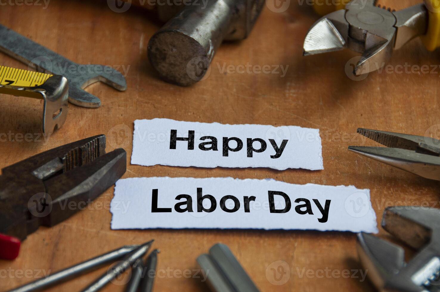 Happy labor day text on torn papers with working tools background. Labor day celebration concept. photo