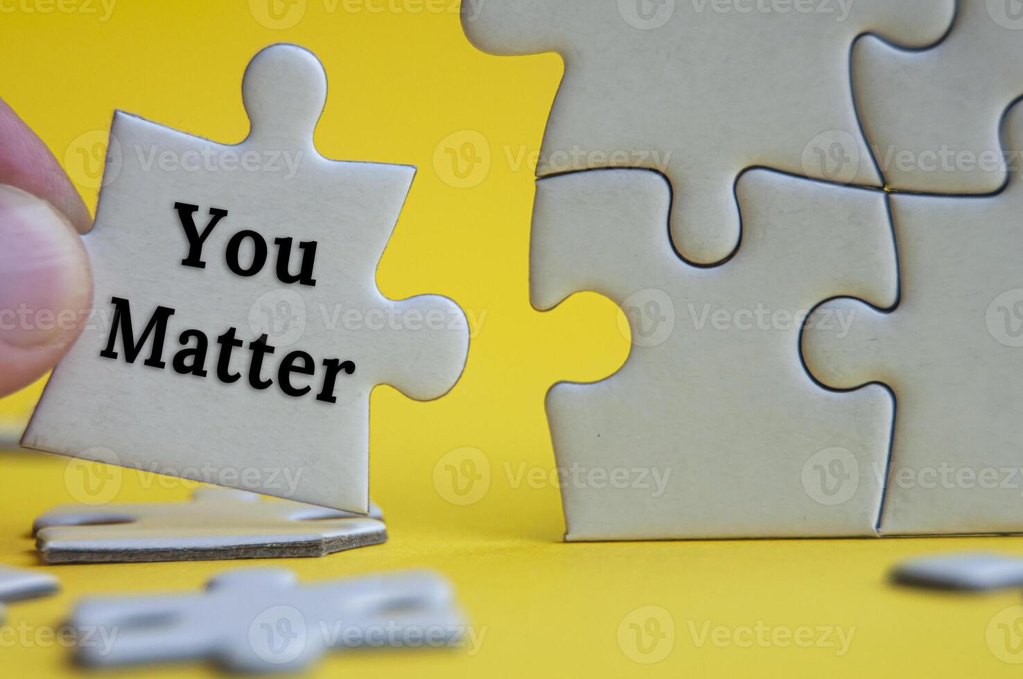 Motivational text on jigsaw puzzle with yellow background - You matter. photo
