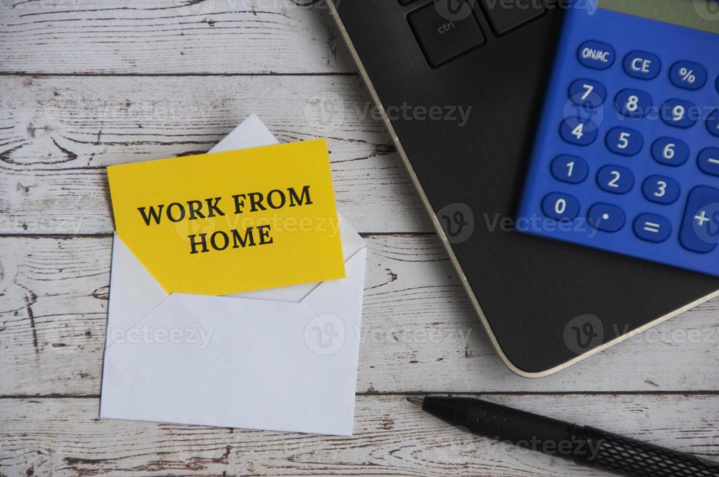 Top view of text - Work from home on notepad in an envelope with office setting background. photo