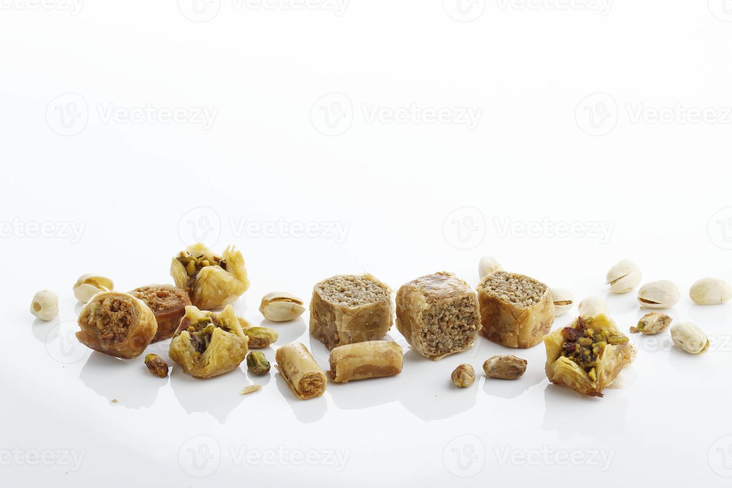 Traditional oriental sweets in white plate with different nuts on a white table photo