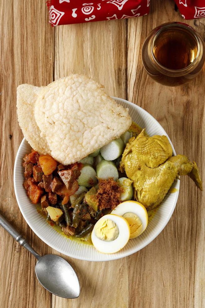 Lontong Cap Go Meh. Peranakan dish of rice cake with chicken curry, spicy chayote curry, boiled egg and hot and spicy liver and potatoes. photo