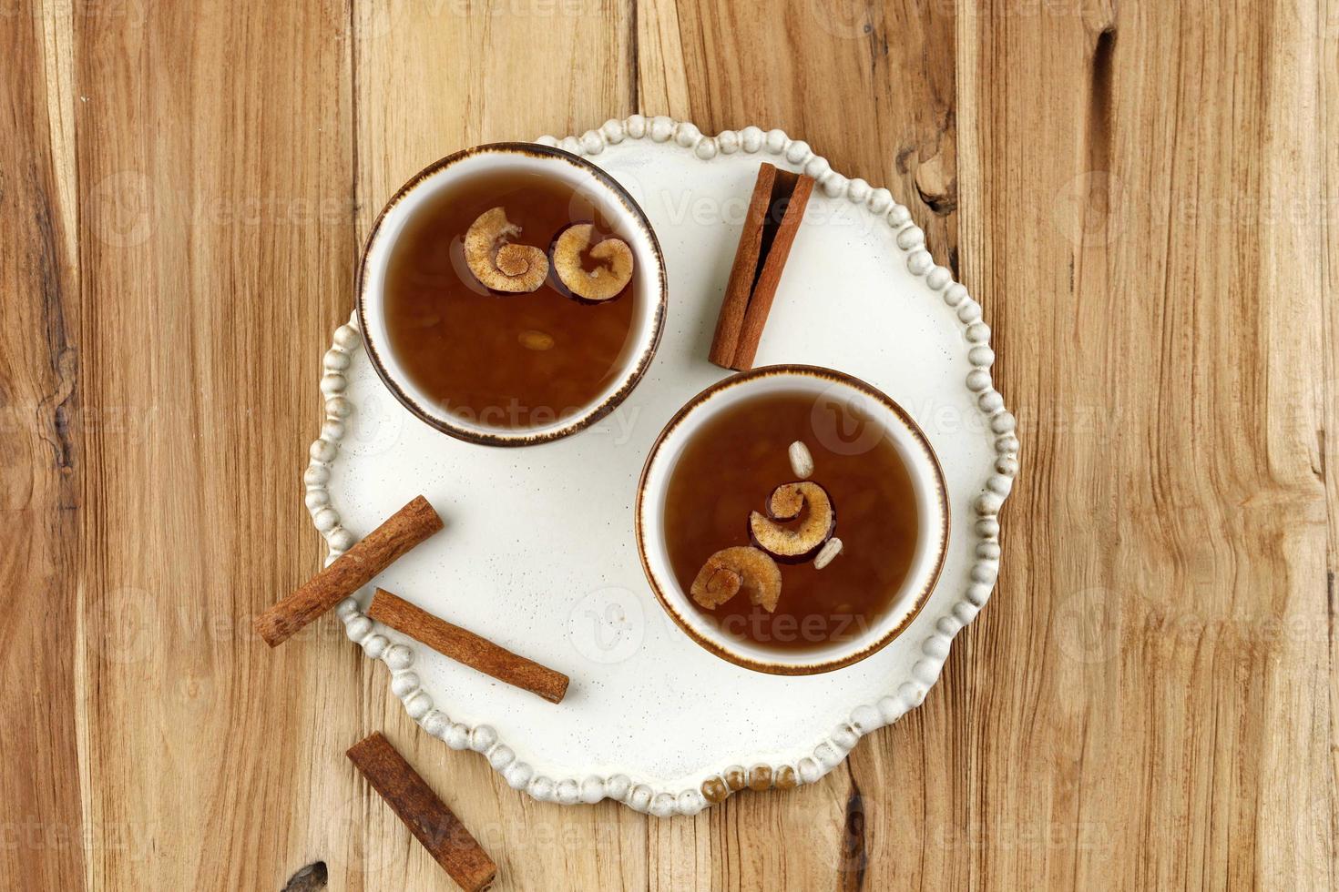 Sujeonggwa, Korean Traditional Cinnamon Punch. Dark Reddish Brown in Color, it is Made from Cinnamon Stick, Gotgam, and Ginger photo