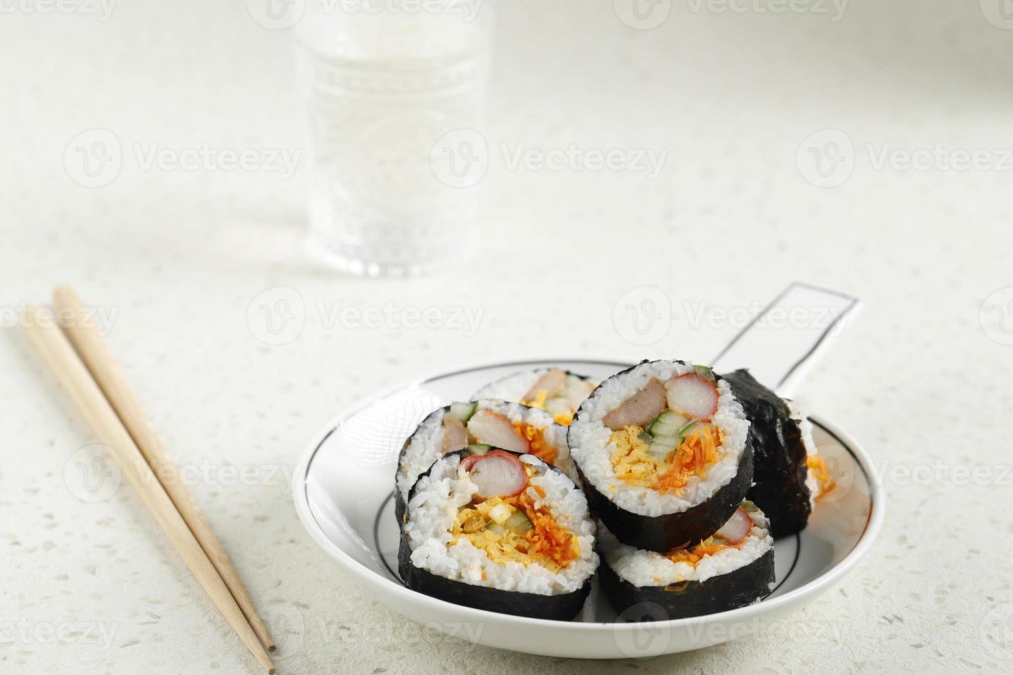 rollo coreano gimbap kimbob o kimbap hecho de bap de arroz blanco al vapor y varios otros ingredientes, como kyuri, zanahoria, salchicha, palito de cangrejo o kimchi y envuelto con alga laver. foto