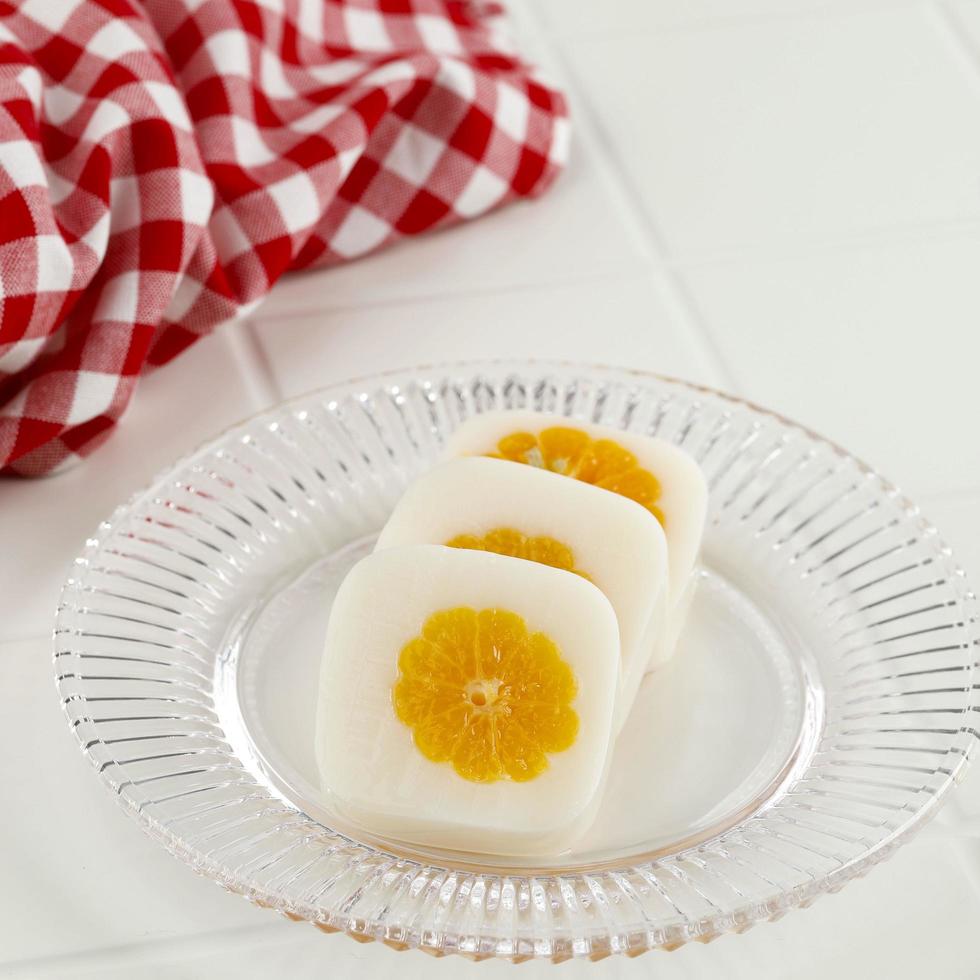 Milk Pudding with Fresh Orange at the Center, on White Table photo