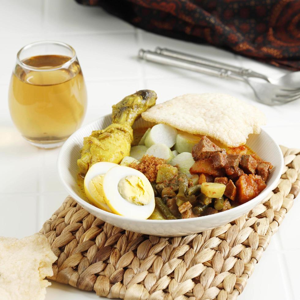 Lontong Sayur Medan, Traditional Indonesian Food, Coconut Broth with Vegetable, Rice Cake, Egg, Rendang Chili, Crackers Krupuk. photo