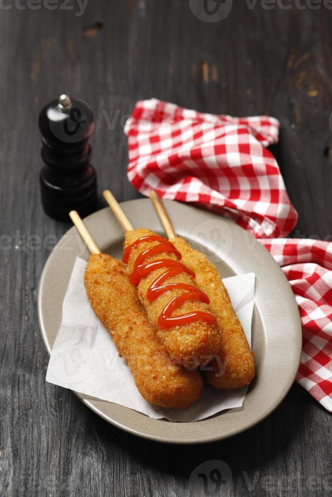 El corn dog es una salchicha en un palito con queso mozarella, rebozada con harina y frita. foto