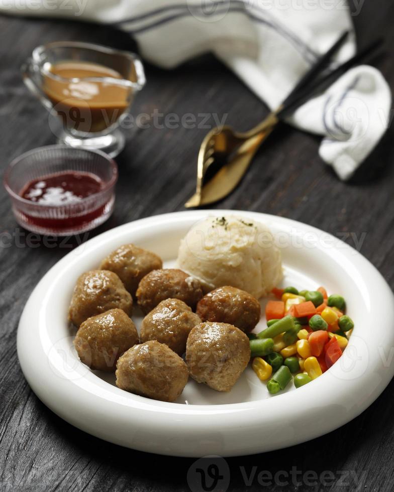 albóndigas suecas con salsa cremosa, puré de papas con mantequilla y salsa de arándanos rojos. foto