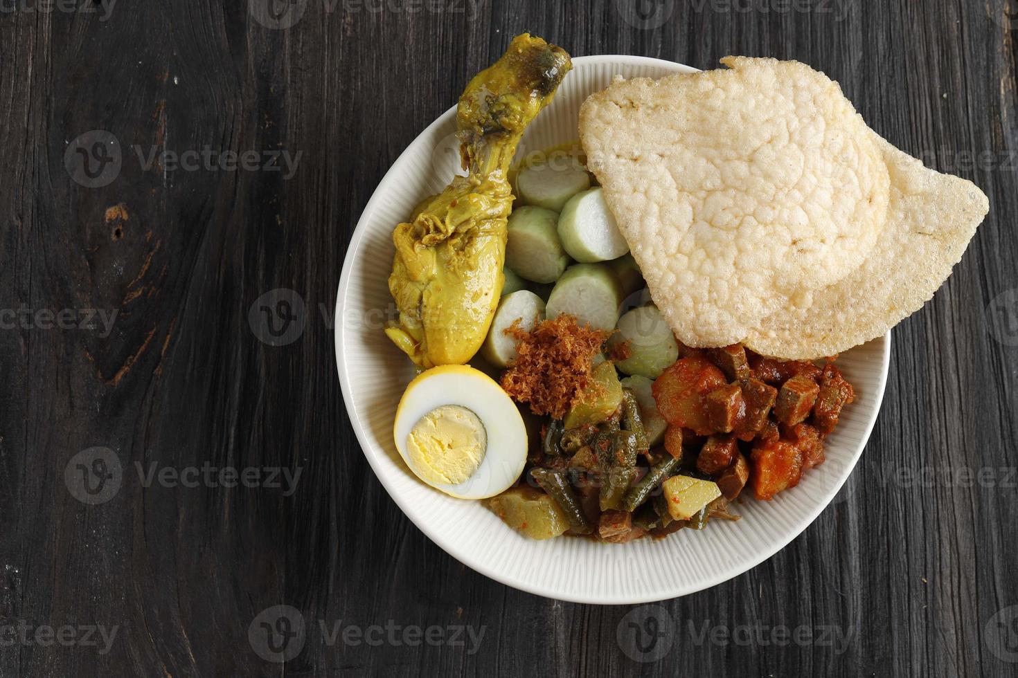 Lontong Cap Go Meh. Peranakan Dish of Rice Cake with Chicken Curry, Spicy Chayote, Boiled Egg, and Shrimps Crackers. photo