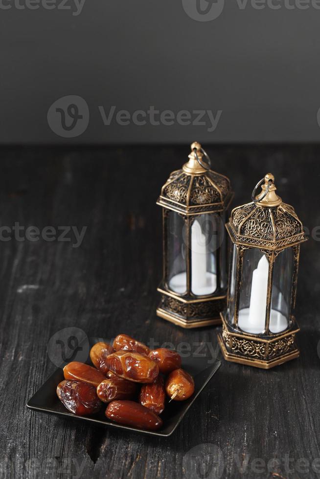 Selected Focus Lantern and Dates on Wooden Table. Ramadan kareem holiday celebration concept, photo