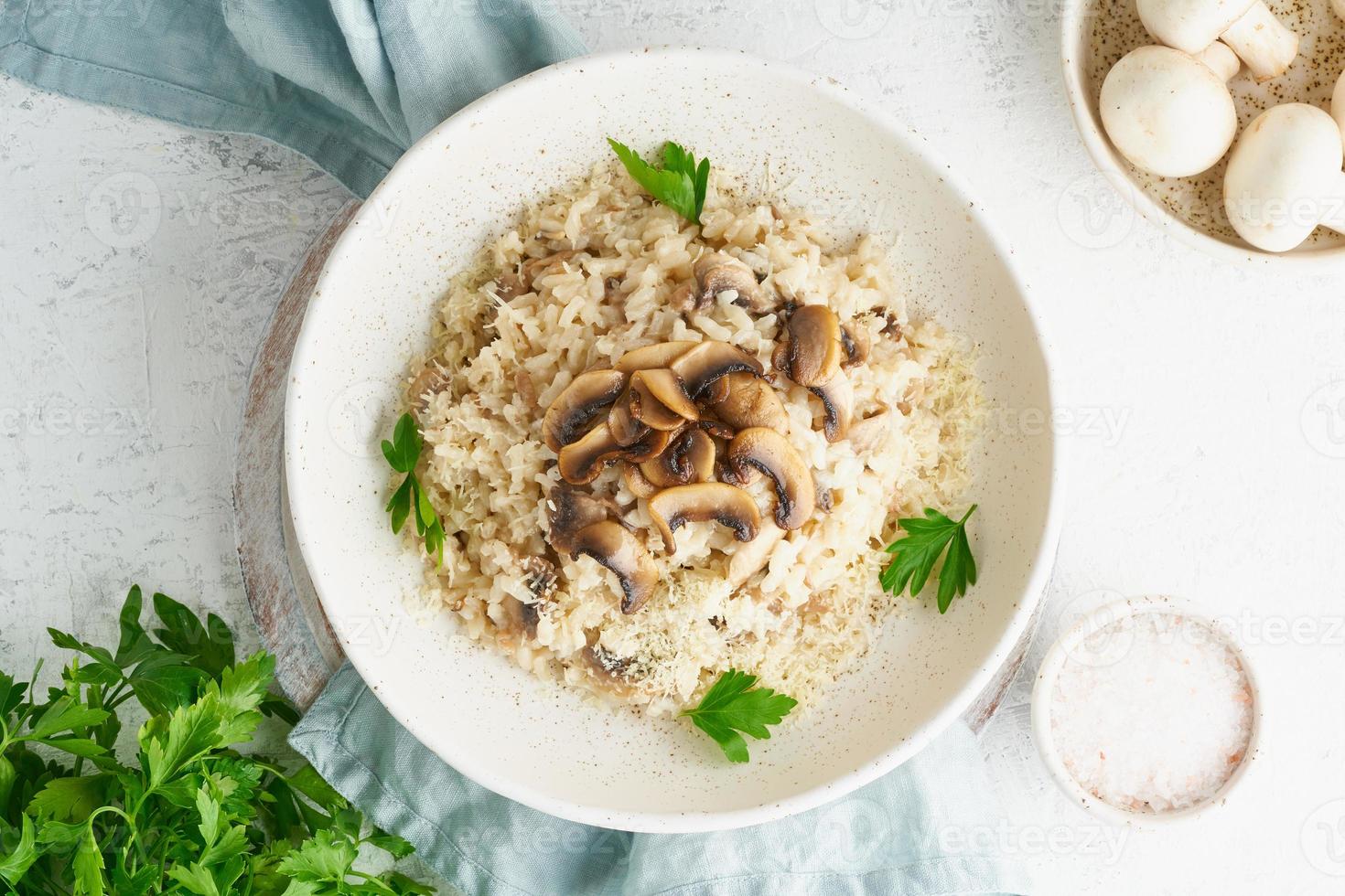 Risotto with mushrooms in plate. Rice porridge with mushrooms and parsley photo