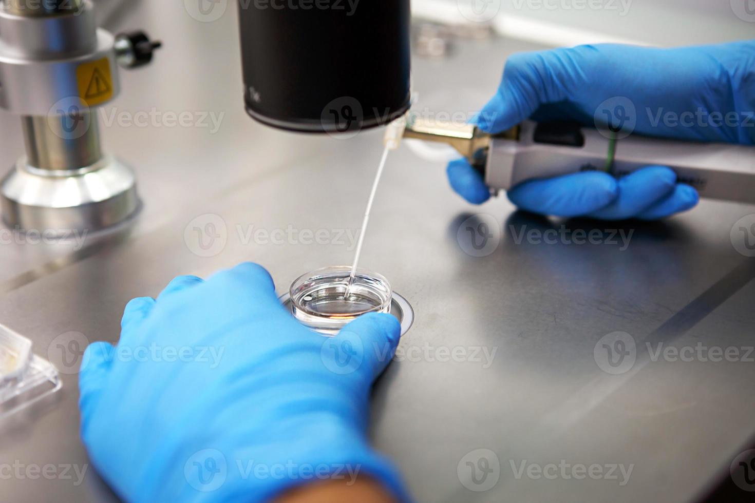 Hands of a scientist in the laboratory with a test tube and a microscope. The invention of the vaccine, a doctor in the clinic of artificial insemination IVF. Tests, fertilization of the egg photo