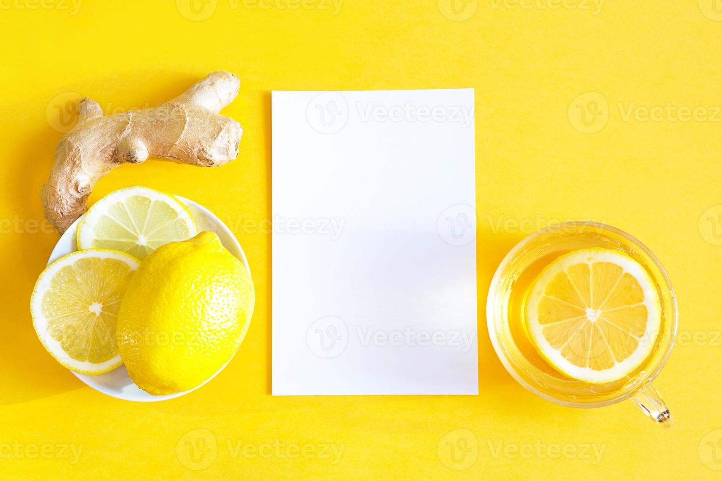 Medicinal tea in a cup, ginger, lemon-strengthen the immune system in the cold season and copy space, sheet for notes. Vitamin drink for health and ingredients on a yellow illuminating background. photo