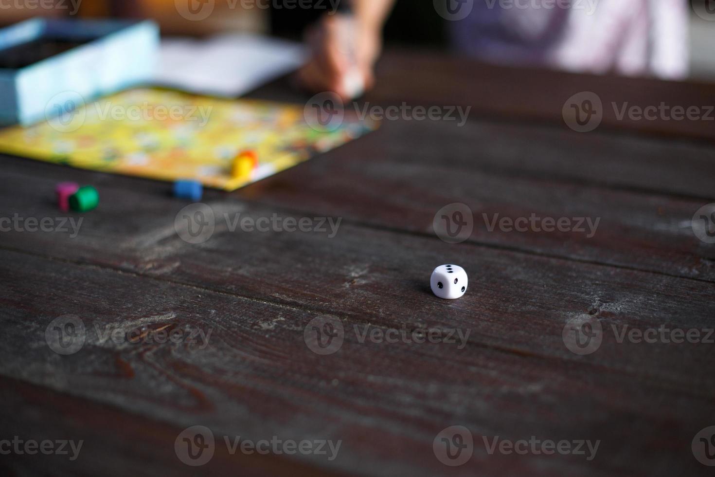 Board game board, chips, cube, timer on a dark wooden table and hands in the background. The concept of teamwork, intellectual relaxation, corporate event, playing at home with children. Copy space photo