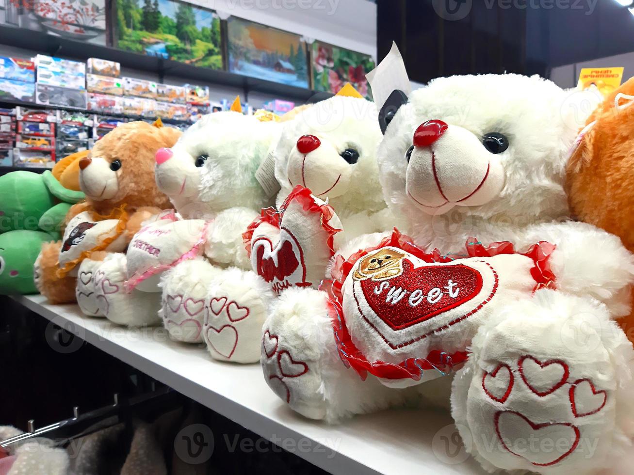 Soft toys bears with a heart on the shop window. Gift to your loved ones for Valentine's Day, shopping. photo