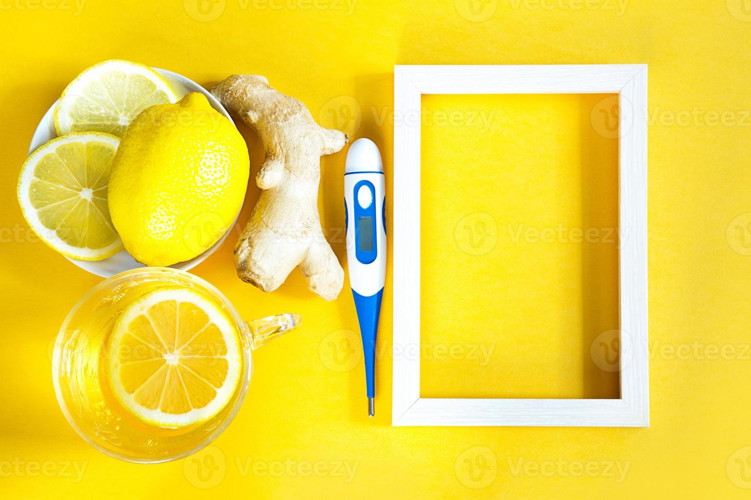 Medicinal tea in a cup, ginger, lemon-strengthen the immune system in the cold season, thermometer and copy space, sheet for notes. Vitamin drink for health and ingredients on yellow background. photo
