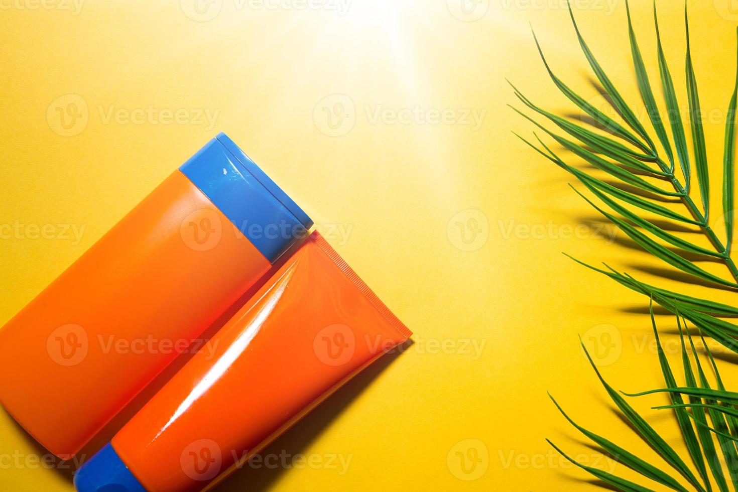 Two tubes with mock up sunscreens on a yellow summer background. UV protection of the skin with an SPF filter, hair care-shampoo and conditioner. A safe tan on the beach. Flat lay - resort on the sea. photo