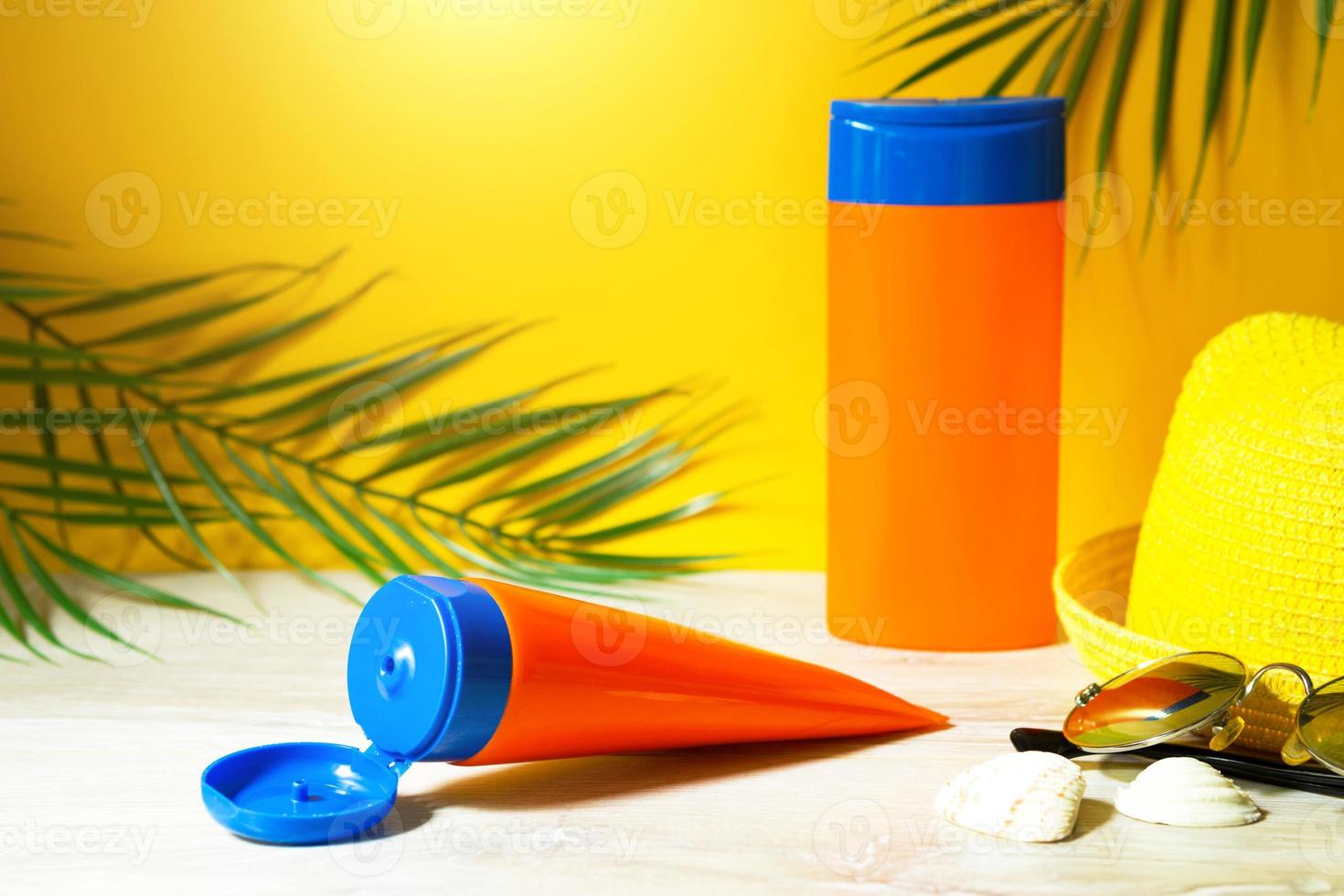 Tubes with mock up sunscreens on the table with yellow summer background. UV protection of the skin with an SPF filter, hair care-shampoo and conditioner. A safe tan on the beach, resort on the sea. photo