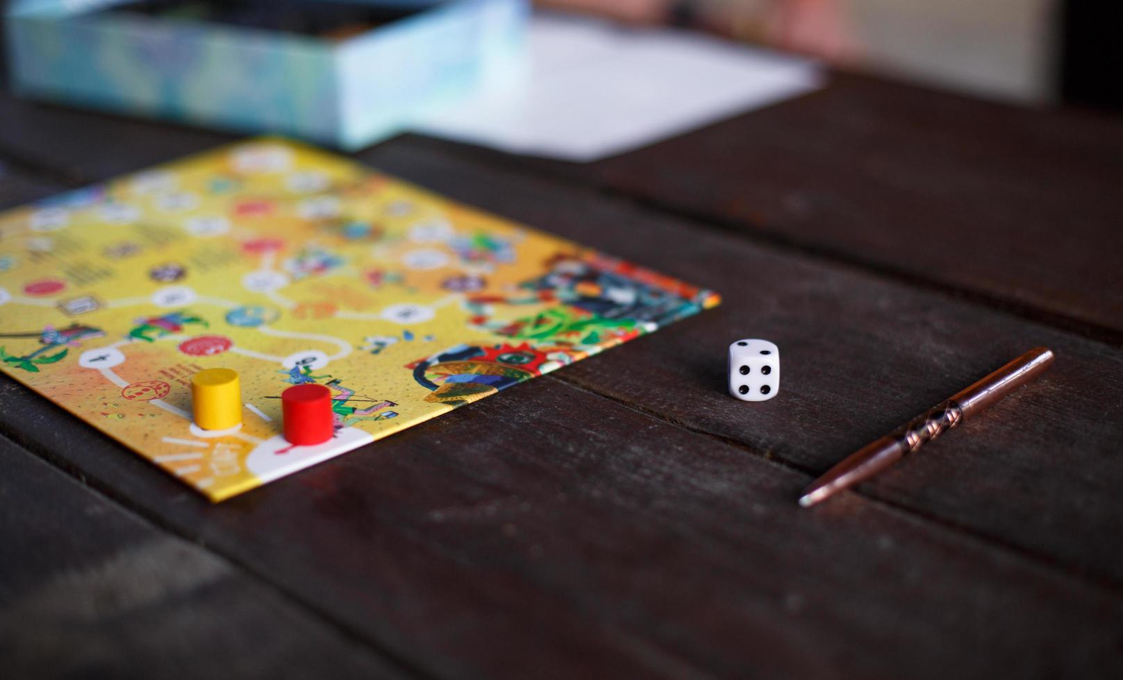 Kaluga, Russia - June 20, 2020. Board game Ekivoki, chips, cube, timer on a table and hands in background. Teamwork, intellectual relaxation, corporate event, playing at home with children. Copy space photo