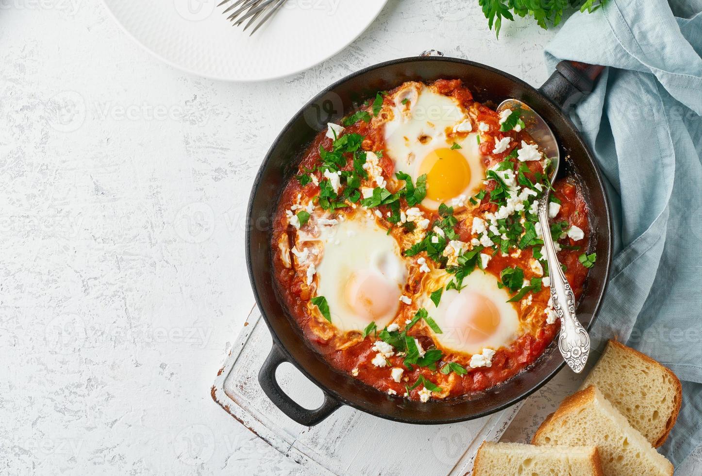 Shakshouka, eggs poached in sauce of tomatoes, olive oil. Mediterranean cuisine. photo