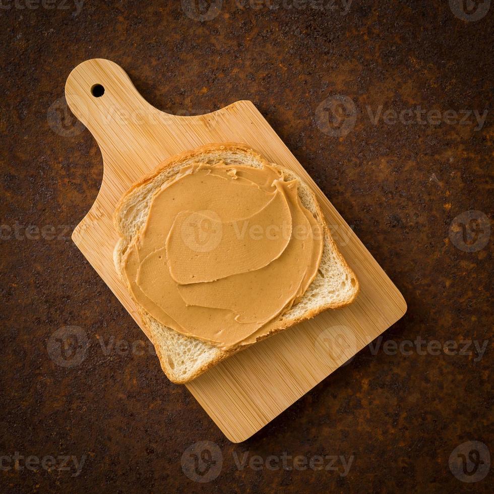 Peanut Butter on Toast. Old rusty metal dark background, top view. photo