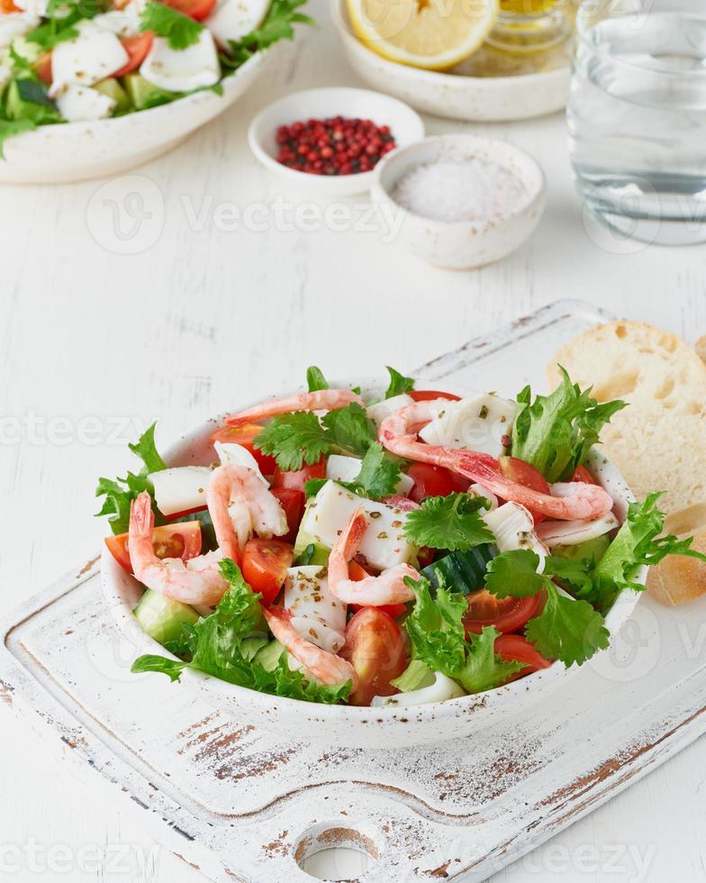 Seafood salad with squid, shrimp, cucumbers, tomatoes and lettuce. LCHF, FODMAP, paleo diet photo