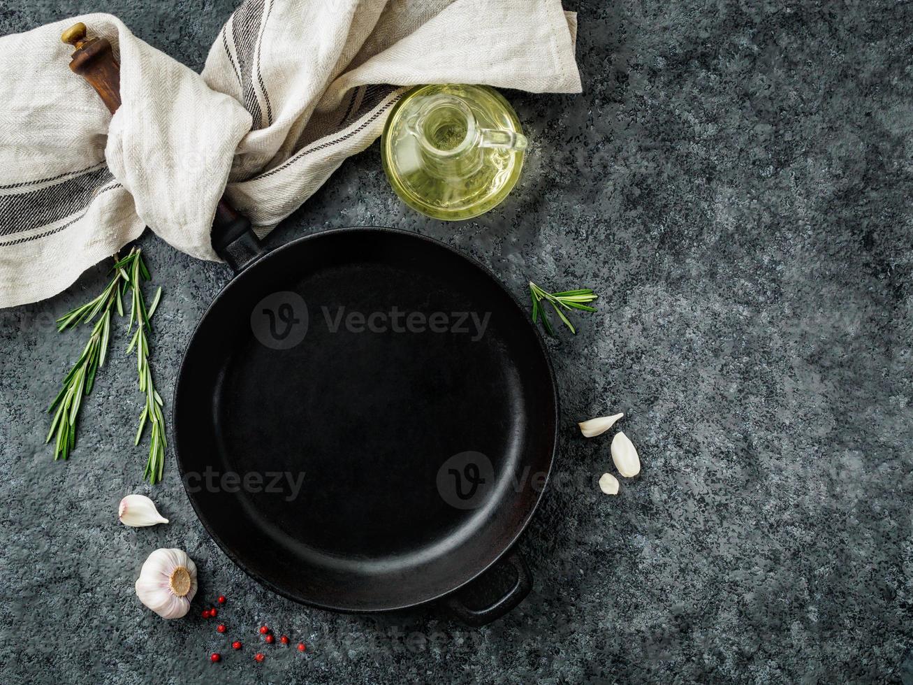 blank cast iron frying pan on dark grey concrete background, top view, blank space for text photo