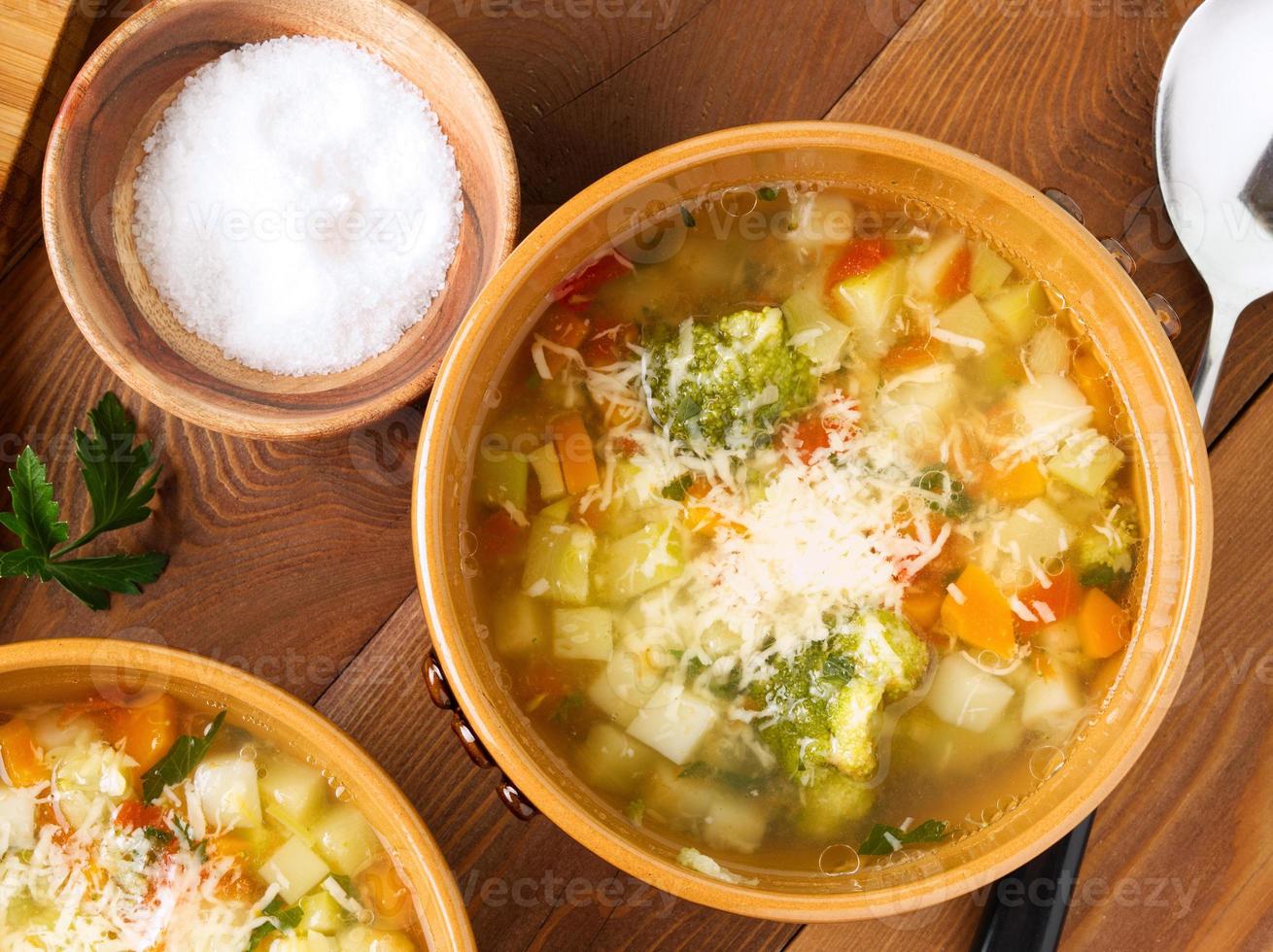 Two bowl of minestrone soup on rustic wooden background, top view, close up. photo