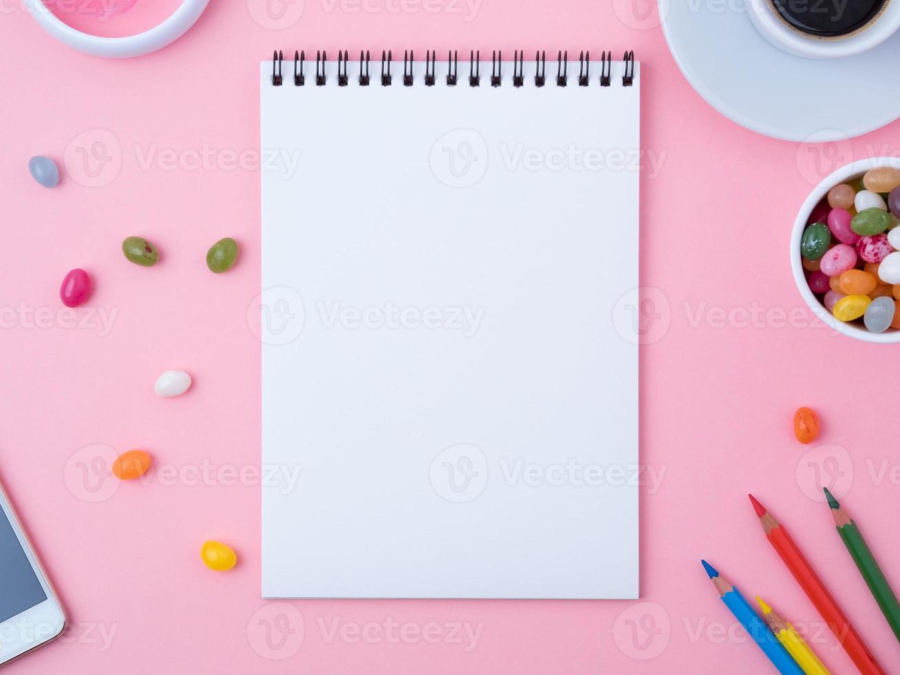 open notebook with a clean white sheet, caramel, lollipops, photo