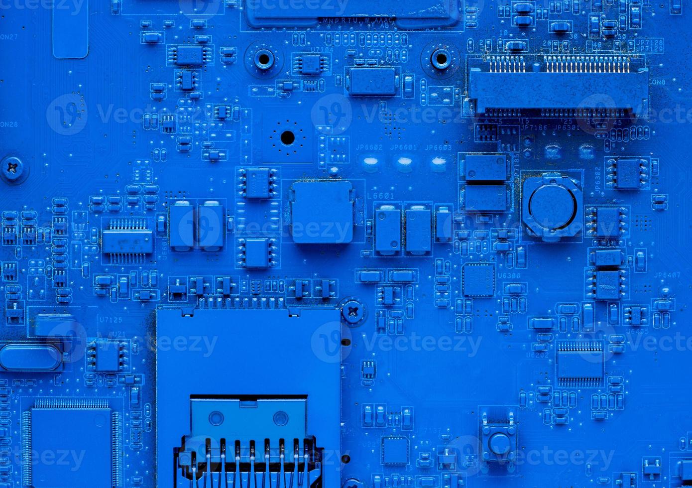 Computer motherboard. Classic blue background with pc backdrop, close up. Single color microchip photo