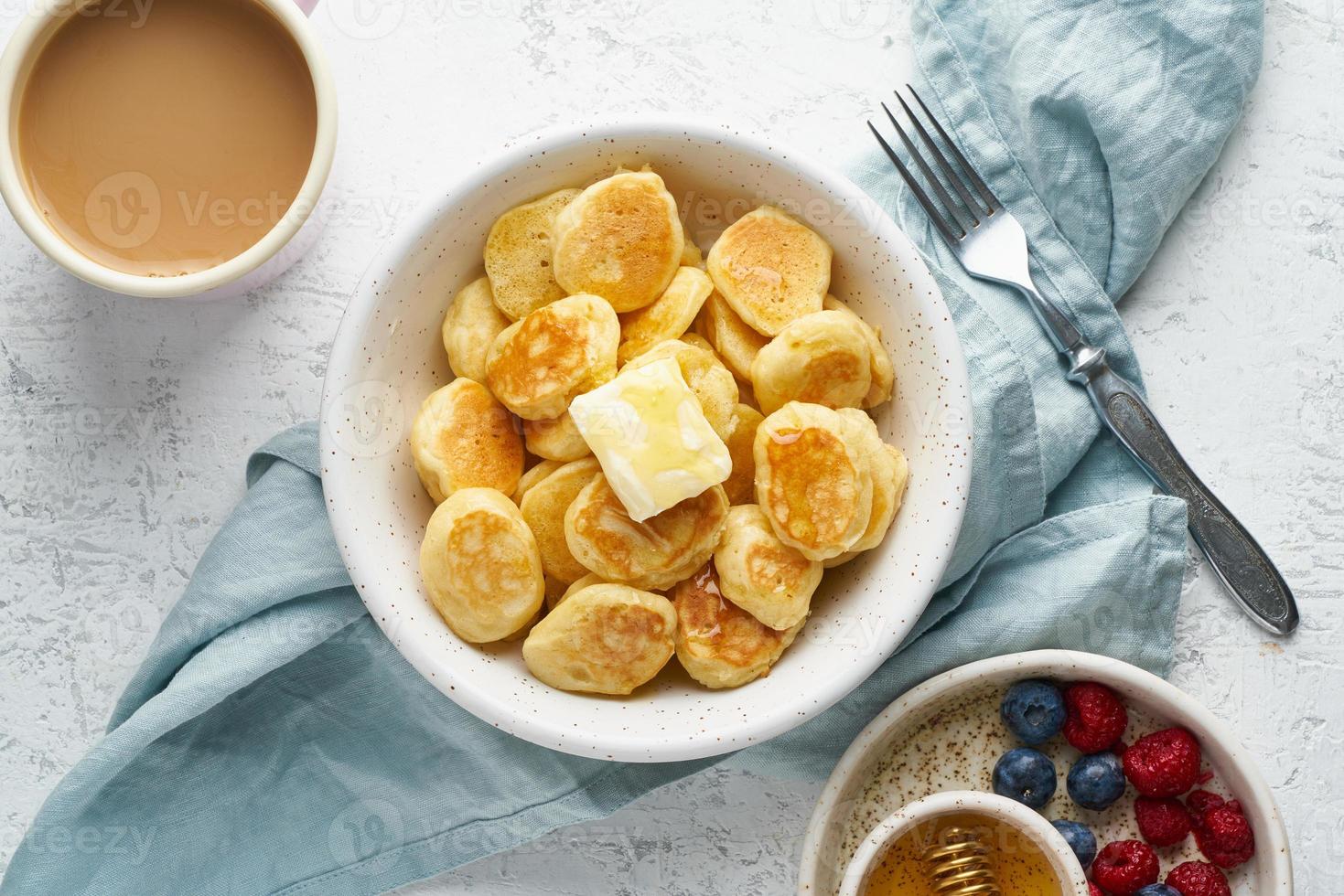 cereal de panqueques, bollo diminuto y delgado y divertido, comida para niños. desayuno con bebida foto