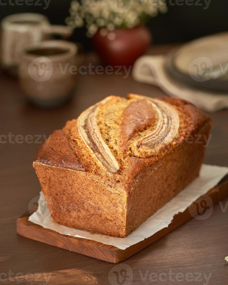Banana bread. Cake with banana, traditional american cuisine. Whole loaf. Side view, close up. photo