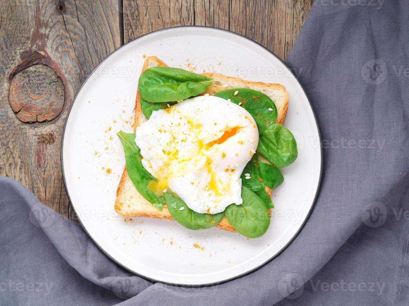 Healthy breakfast with toast and poached egg with green salad, spinach. Top view. photo