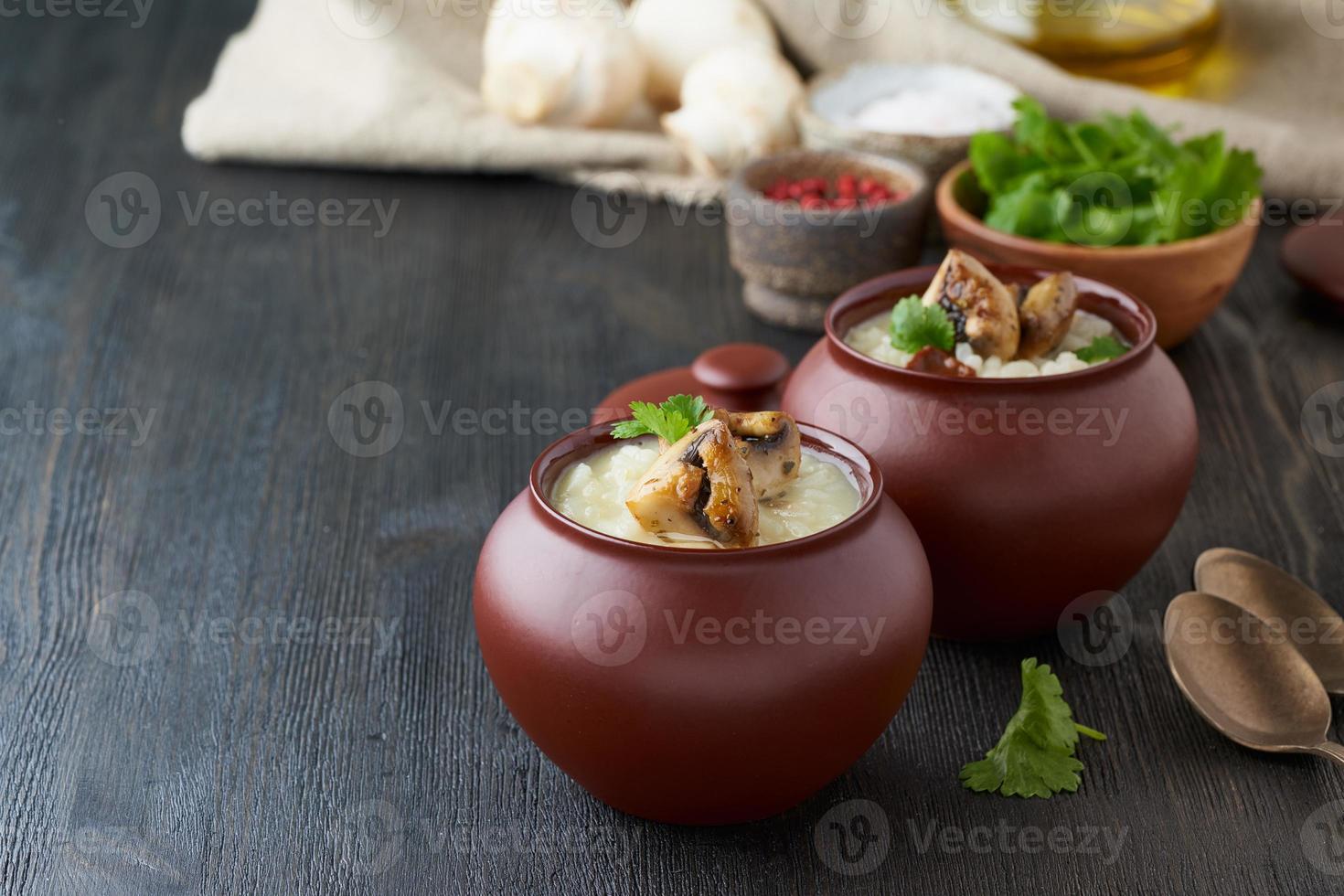 Unconventional unusual serving of risotto with mushrooms in pot. Rice porridge with mushrooms. photo