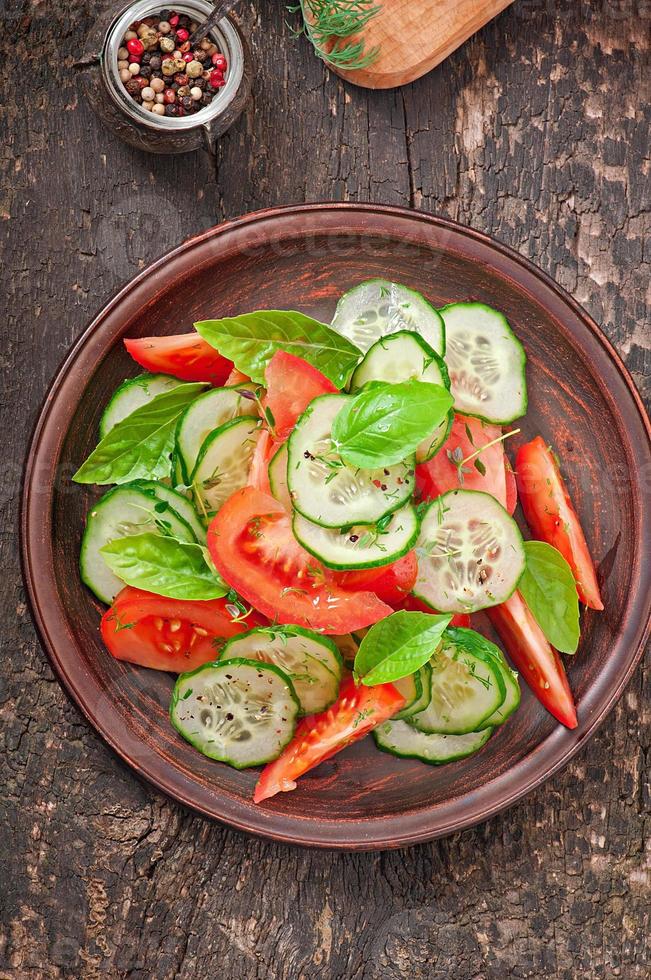 Tomato and cucumber salad with black pepper and basil photo