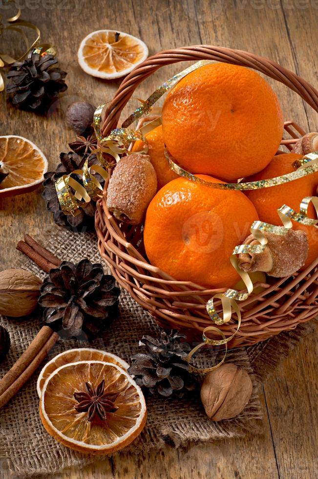 Tangerines and spices on a wooden background photo