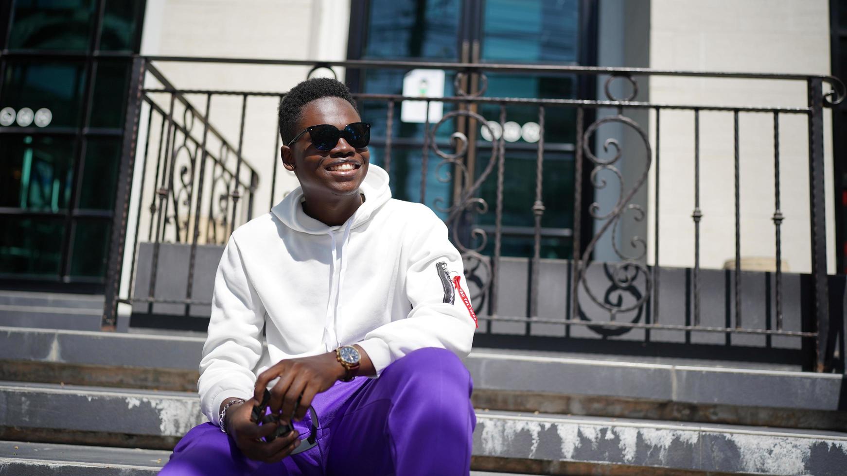 Afro American man having fun walking in city center - Happy young guy enjoying time a sunset outdoor - Millennial generation lifestyle and positive people attitude concept photo