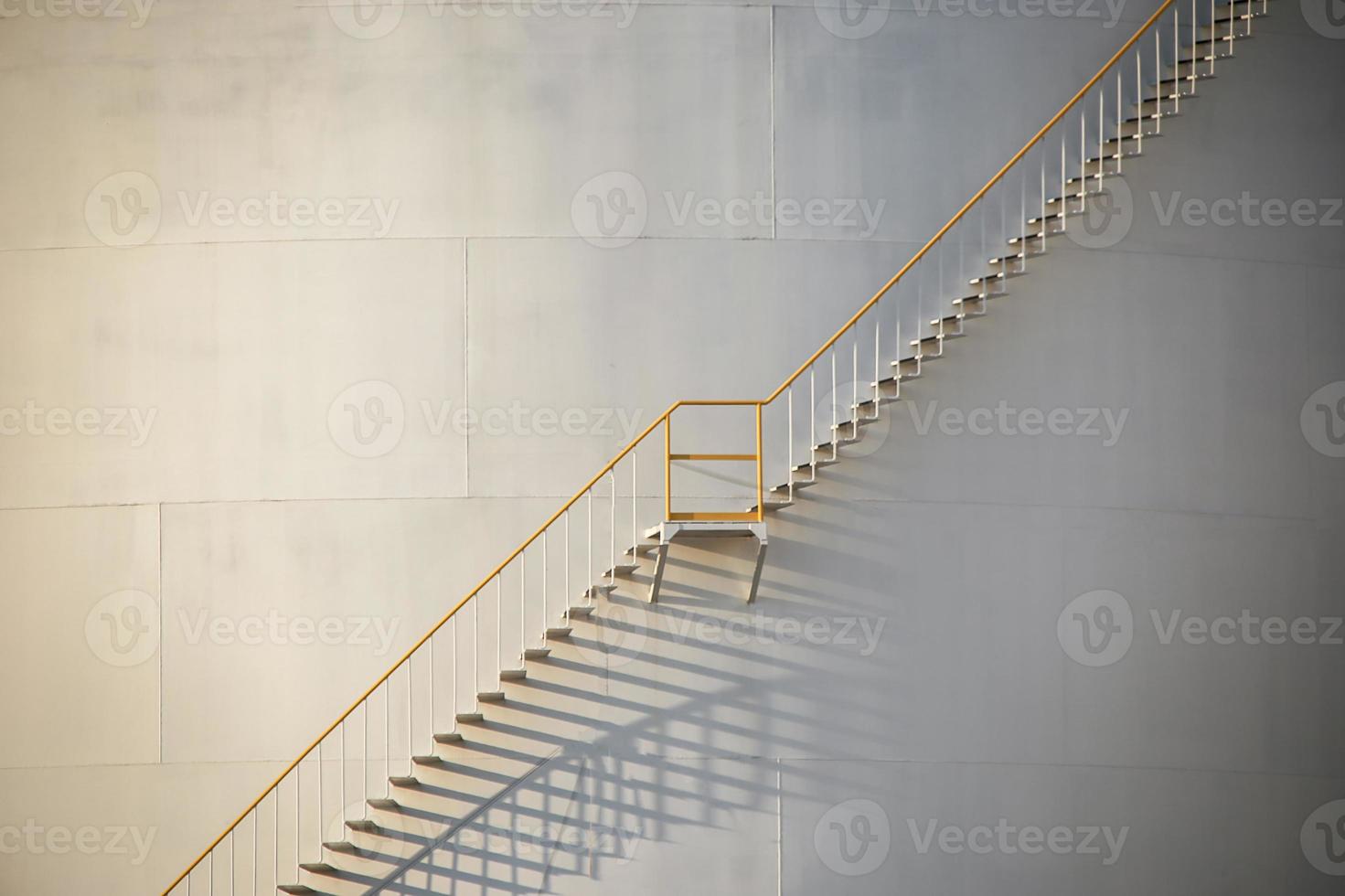 large Industrial tanks for petrol and oil with blue sky.Fuel tanks at the tank farm. metal stairs on the side of an industrial oil container. Staircase on big fuel tank photo