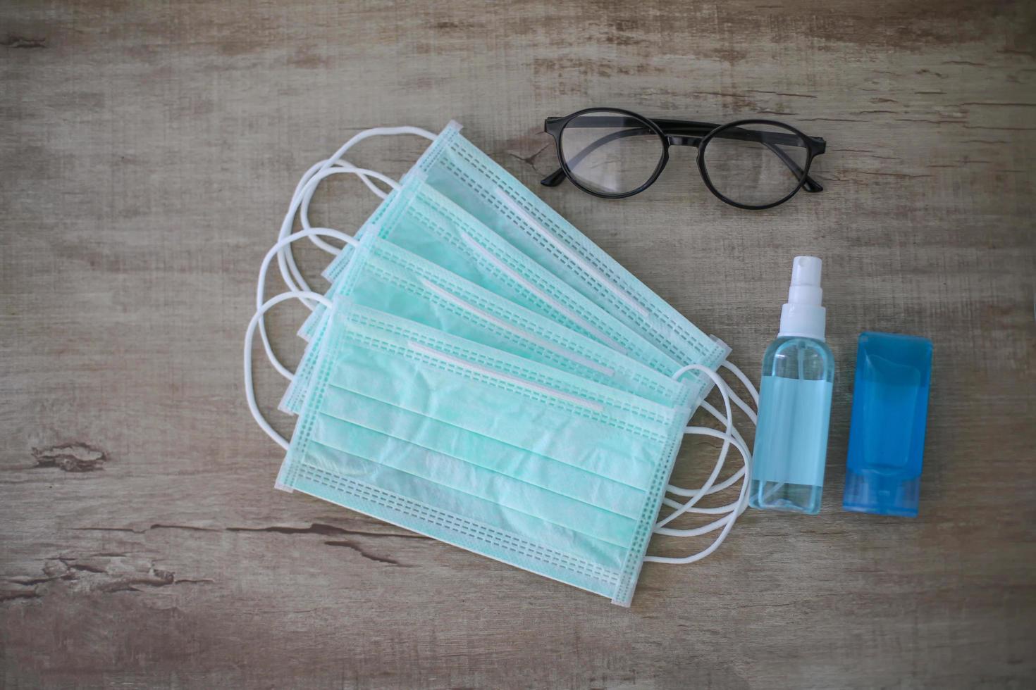 Hygiene. Cleaning Hands. Washing hands with alcohol gel or soap. flat lay over face mask and alcohol spray and eyeglasses on table. . Covid19. Coronavirus. photo