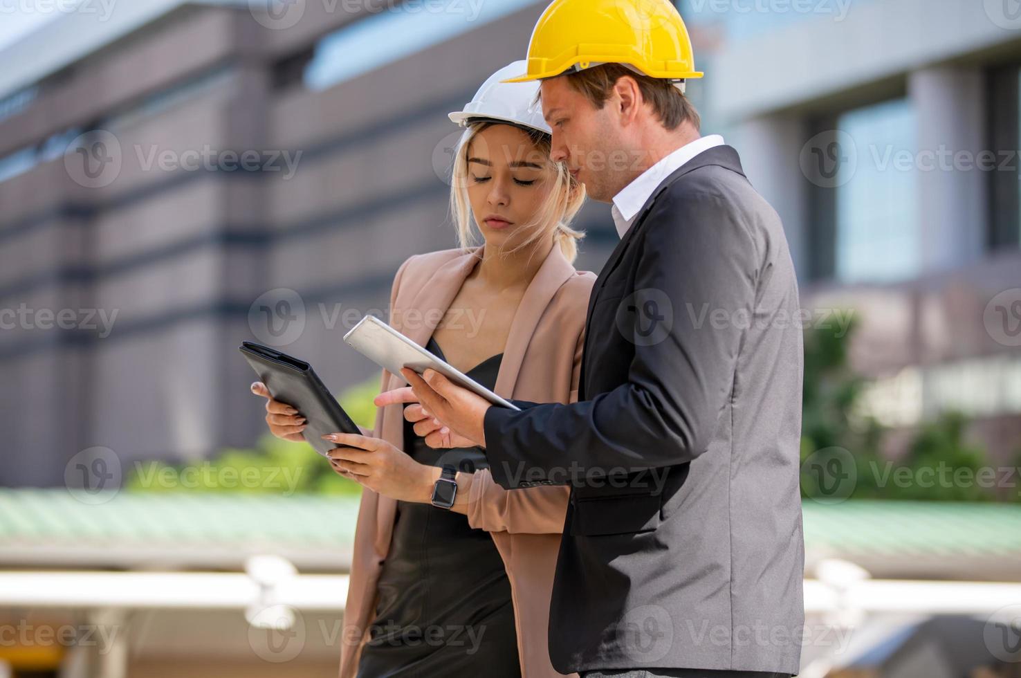 young woman architect in construction helmet makes notes in the drawing photo