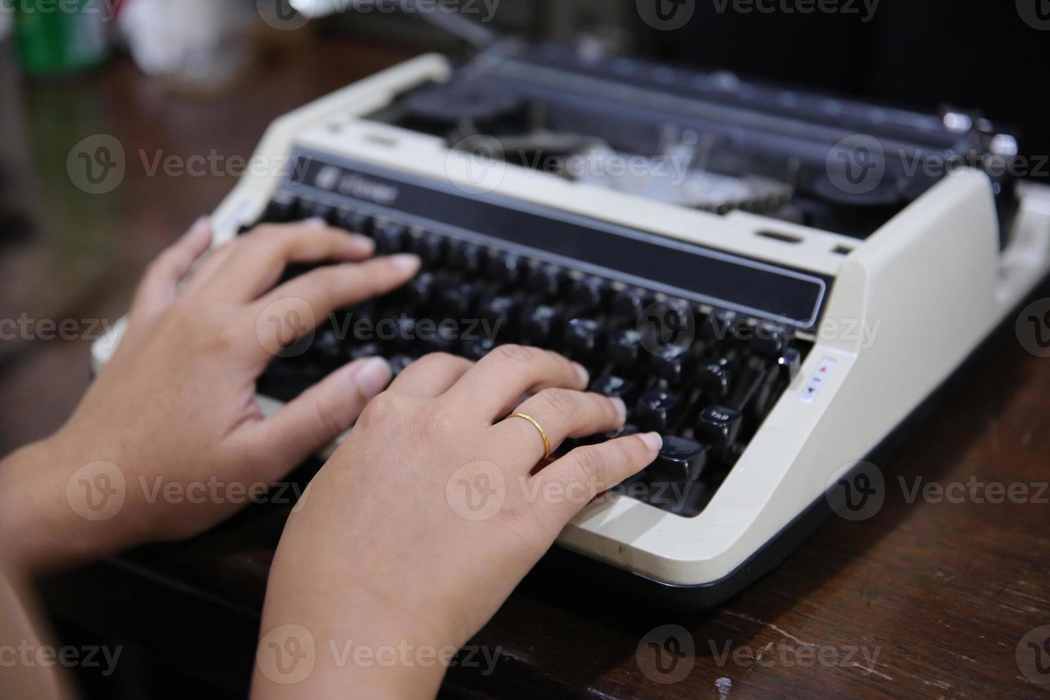 primer plano en la mano de las mujeres escribiendo en una máquina de escribir. foto