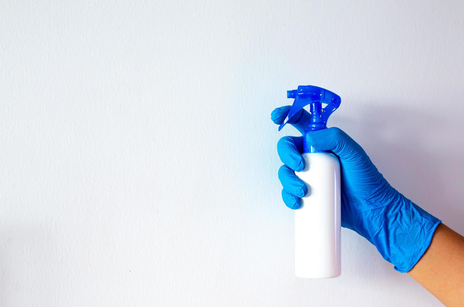 Person, a hand in a blue rubber glove in the picture, removes and washes bathroom sink photo