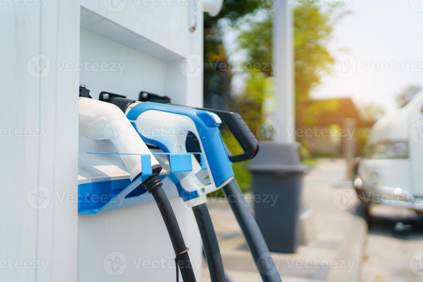 Modern electric vehicle charging connector plugs at ev charging station. DC or direct current and AC or alternating current charging connectors for EV car. photo