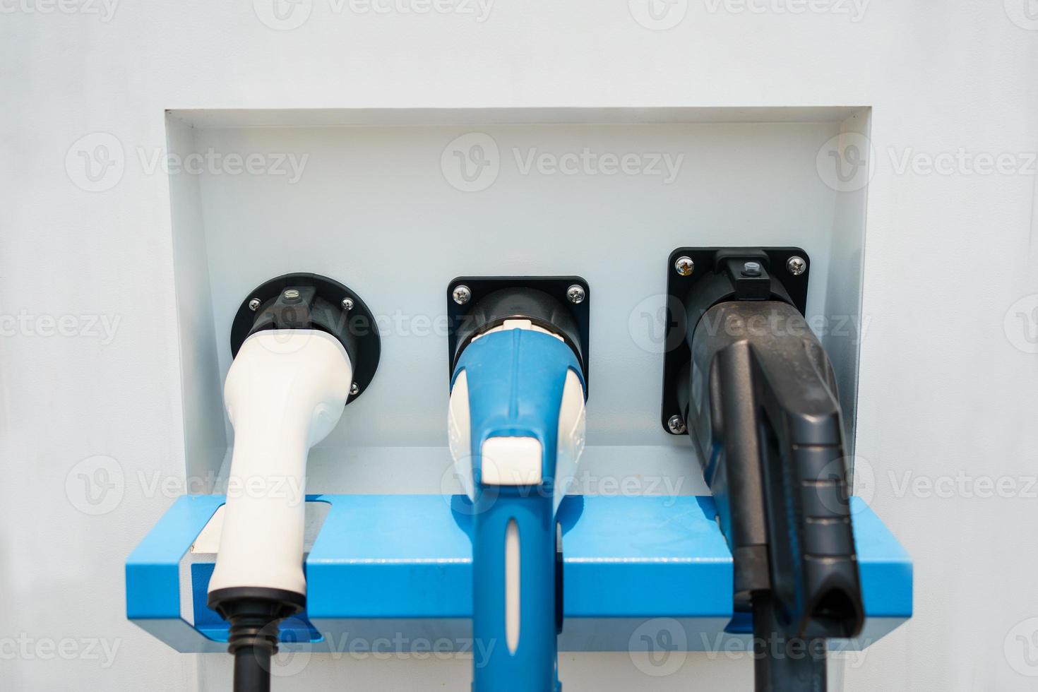 Modern electric vehicle charging connector plugs at ev charging station. DC or direct current and AC or alternating current charging connectors for EV car. photo
