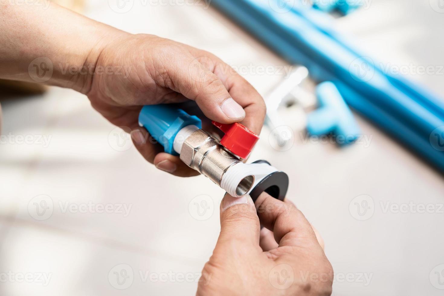 plumber putting teflon thread tape on the thread , Preparing to connect to PVC Pipe at home photo