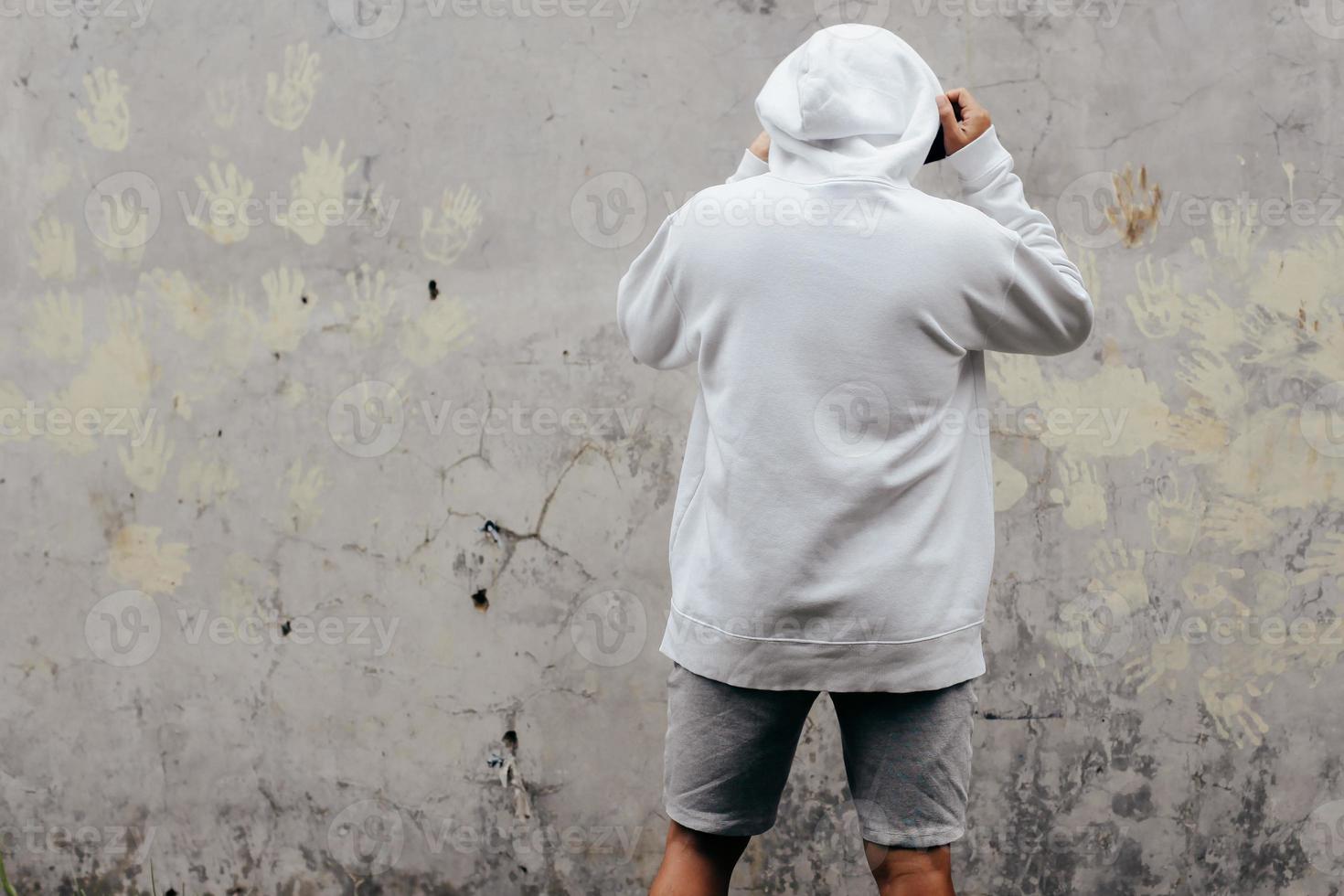 Back View Hoodie Mockup of a Man standing facing the wall photo