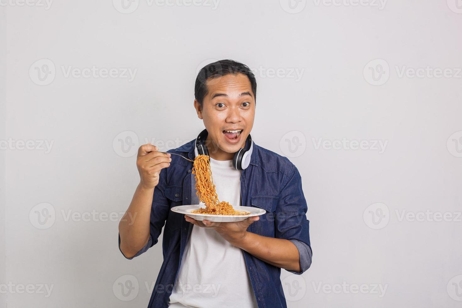 hombre asiático comiendo fideos instantáneos y se sorprende con lo delicioso que es foto