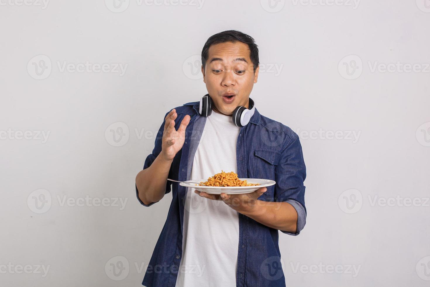 Asian man eating instant noodle and feel surprise with how delicious it is photo