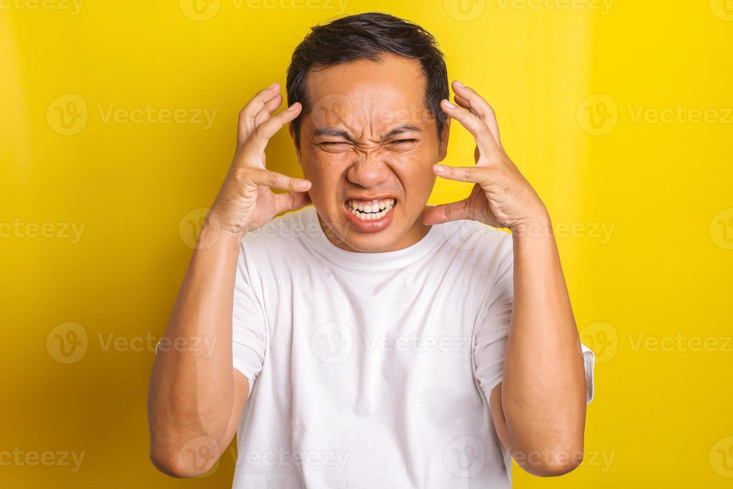 Close-up portrait of annoyed and angry expression on the face of young asian man photo