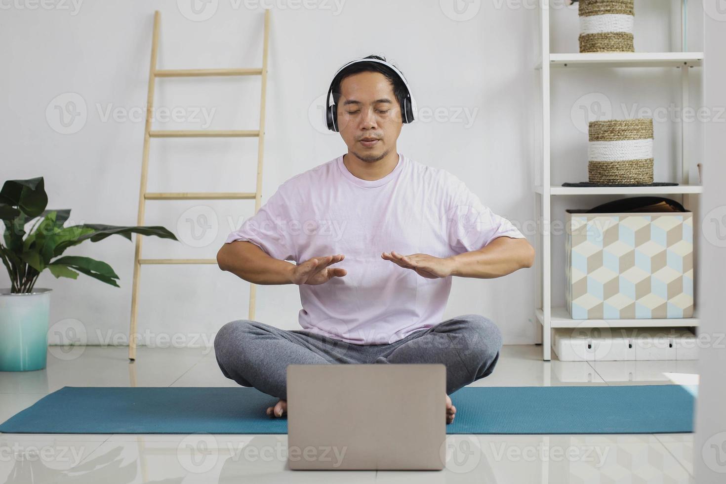 Handsome young asian man taking a breath getting ready for meditation at home photo