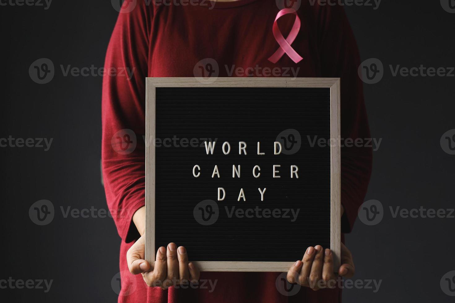 Woman Wearing Pink Ribbon And Message Board For World Cancer Day and Breast Cancer Awarness photo